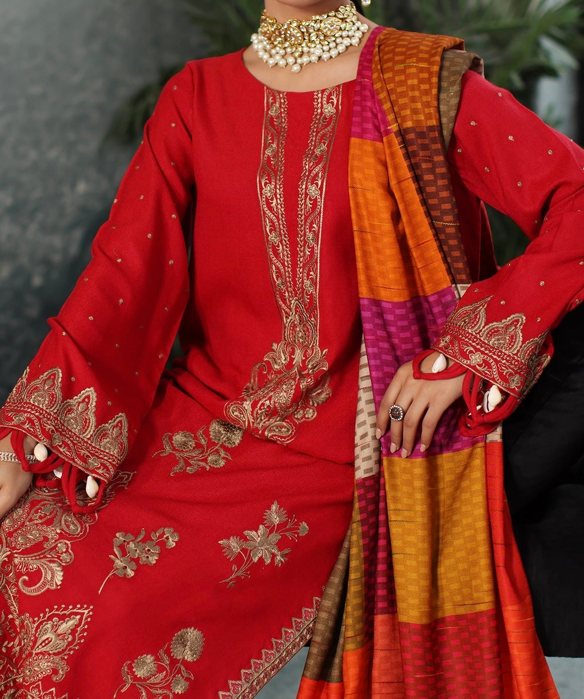 Close-up of intricate embroidery on red leather shirt with gold accents – Party Wear Outfit